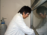 ドラフトの前で白衣＆安全眼鏡の化学の正装で実験操作